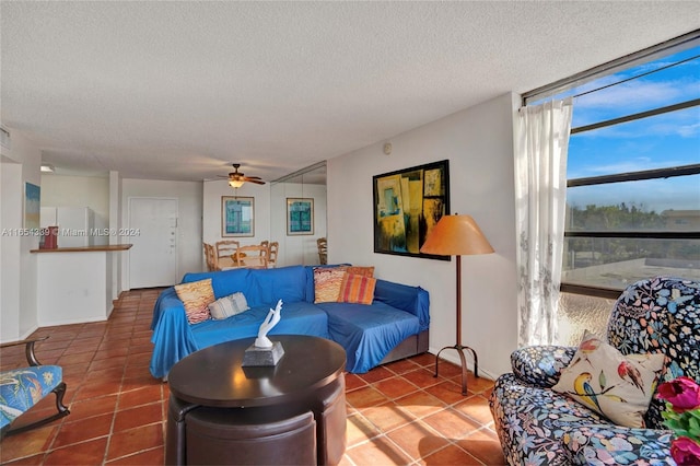 tiled living room featuring a textured ceiling and ceiling fan