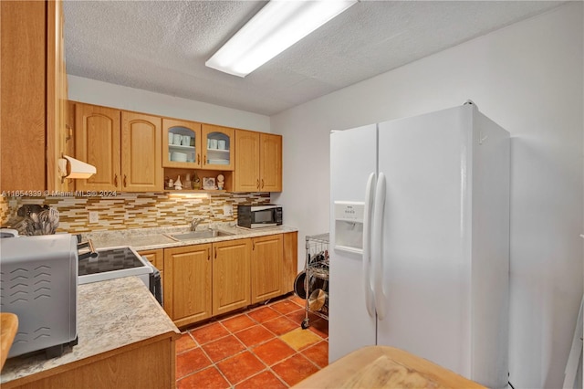 2500 NE 135th St Unit C301, North Miami, FL 33181 - kitchen with white refrigerator with ice dispenser, a sink, black microwave, custom exhaust hood, and decorative backsplash