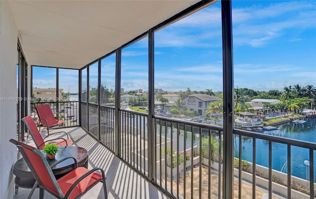 sunroom featuring a water view