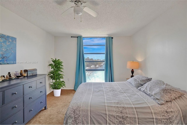 carpeted bedroom with ceiling fan and a textured ceiling