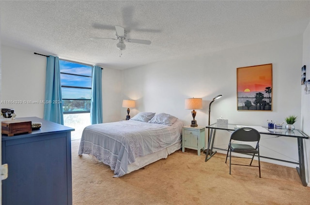 carpeted bedroom with ceiling fan, access to outside, and a textured ceiling