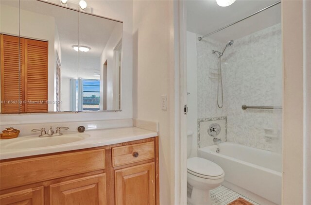 full bathroom with tile patterned floors, tiled shower / bath, toilet, and vanity