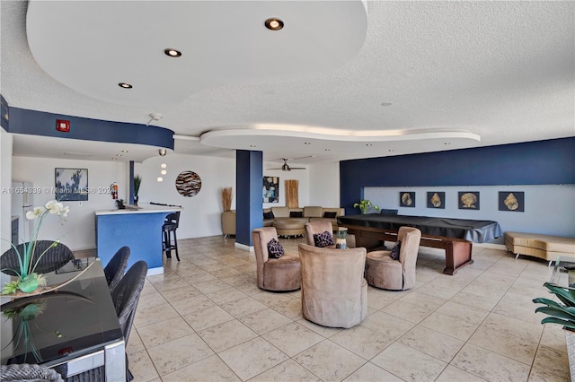 living room with billiards, light tile patterned floors, and a textured ceiling