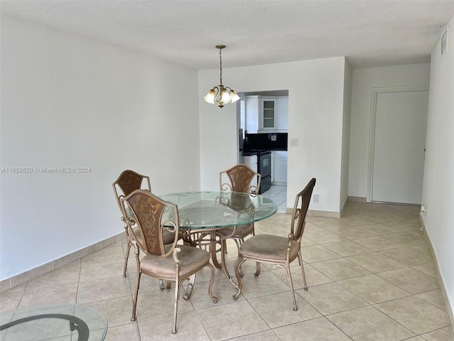 dining room featuring light tile patterned flooring, a notable chandelier, and a textured ceiling