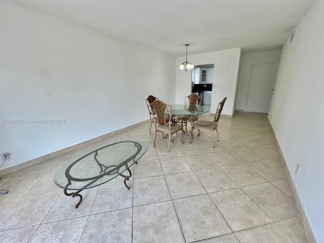 unfurnished dining area with a textured ceiling, a chandelier, and light tile patterned floors