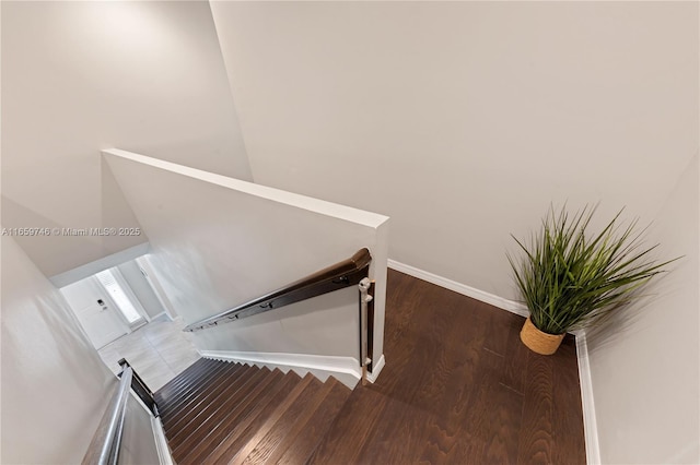 stairway with baseboards and wood finished floors