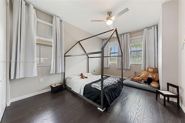 bedroom with ceiling fan, dark wood finished floors, and baseboards