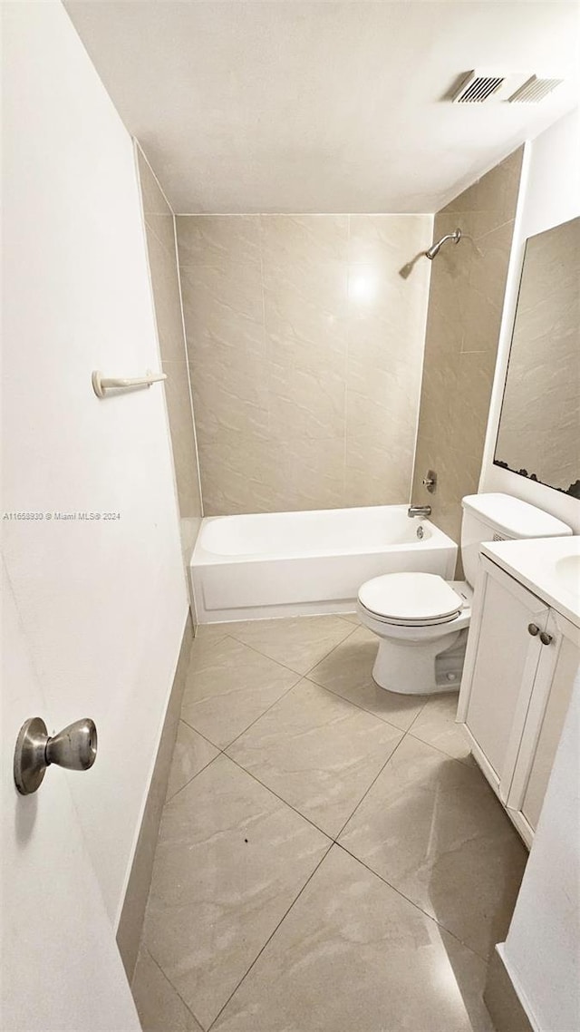 full bathroom with tile patterned floors, toilet, tiled shower / bath combo, and vanity