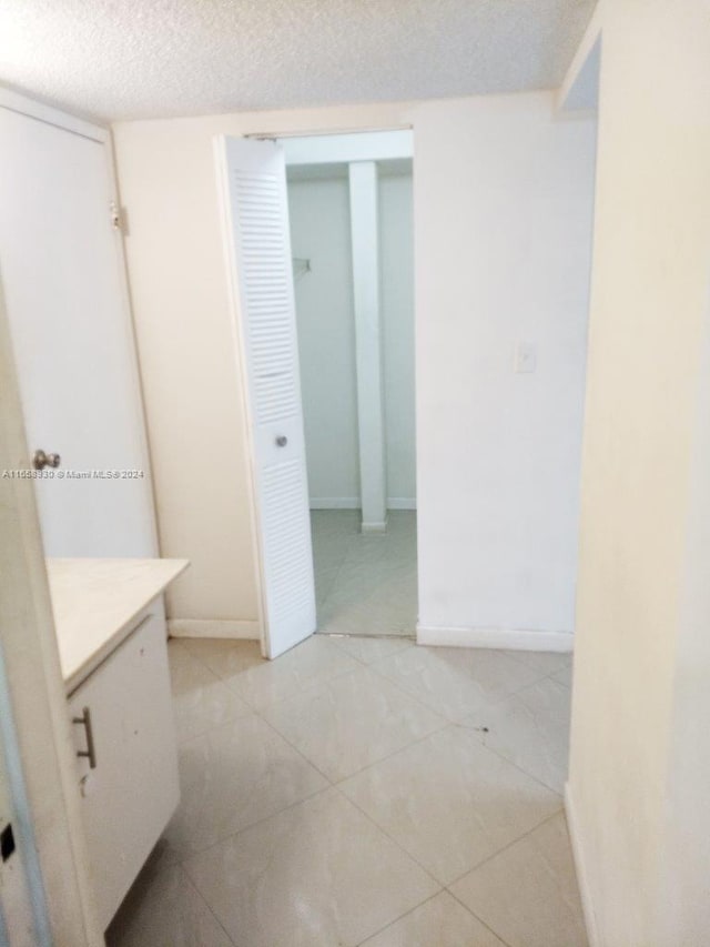 bathroom featuring a textured ceiling, vanity, and tile patterned floors