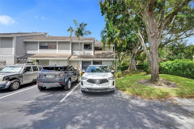 multi unit property featuring a balcony and a front yard