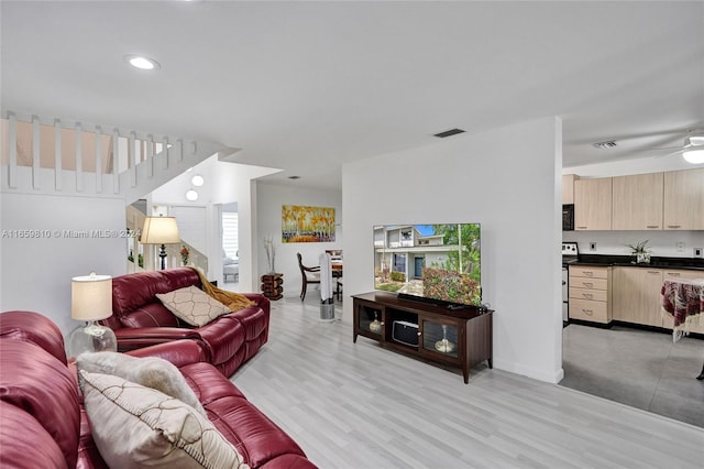 living room featuring ceiling fan, a wealth of natural light, and light hardwood / wood-style flooring