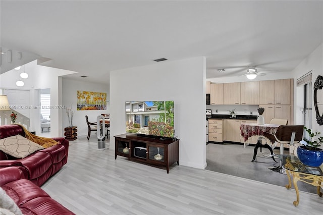 living room featuring light wood-type flooring, ceiling fan, and plenty of natural light