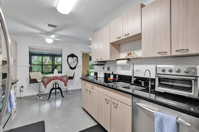 kitchen with light brown cabinetry, stainless steel dishwasher, and ceiling fan