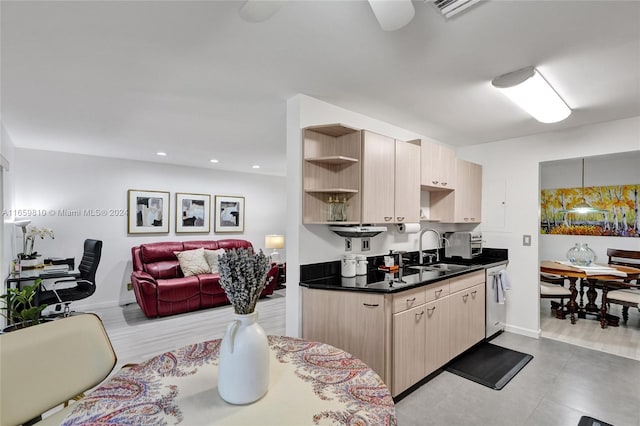 kitchen with light brown cabinetry, light hardwood / wood-style flooring, stainless steel dishwasher, and sink