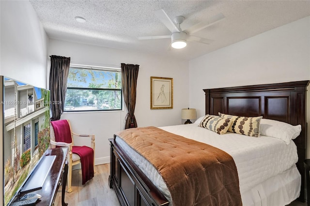 bedroom with light wood-type flooring, a textured ceiling, and ceiling fan