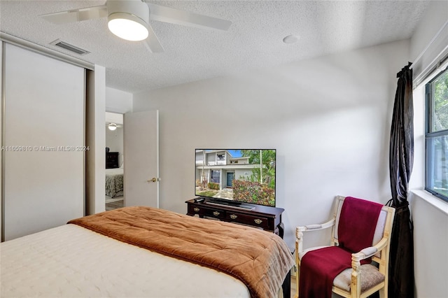 bedroom with a textured ceiling and ceiling fan