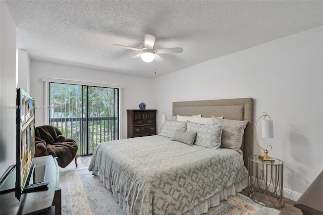 bedroom with ceiling fan, hardwood / wood-style flooring, access to exterior, and a textured ceiling