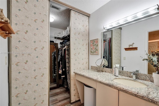 bathroom featuring a textured ceiling, vanity, and wood-type flooring