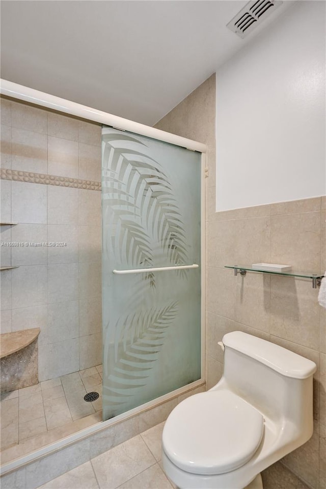 bathroom with tile walls, toilet, an enclosed shower, and tile patterned flooring