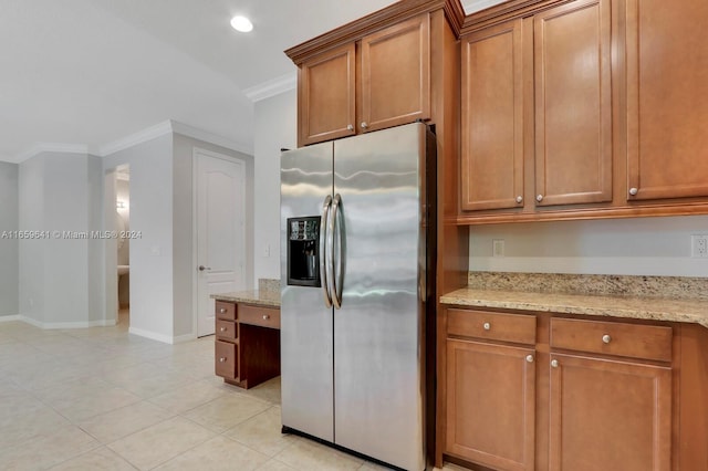 kitchen featuring stainless steel refrigerator with ice dispenser, light stone counters, light tile patterned floors, and crown molding