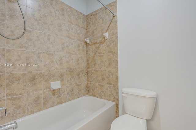 bathroom featuring toilet and tiled shower / bath