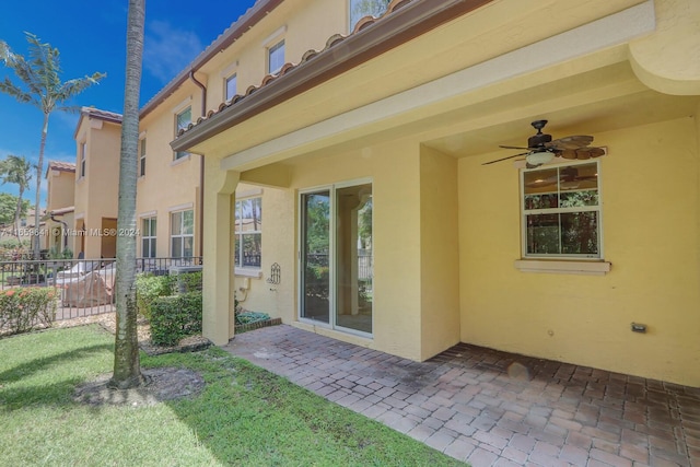 rear view of house featuring a patio, a yard, and ceiling fan