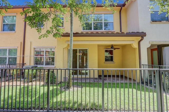 view of front of home featuring ceiling fan and a front lawn