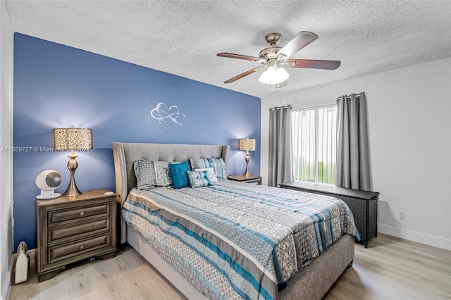 bedroom featuring a textured ceiling, ceiling fan, and light hardwood / wood-style floors