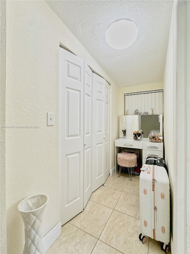 interior space featuring a textured ceiling and light tile patterned flooring