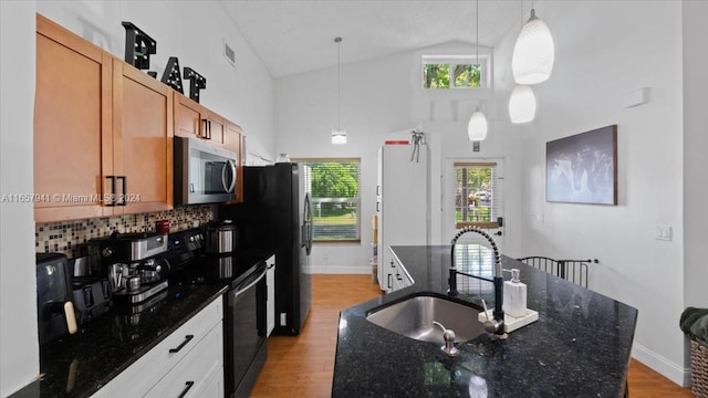 kitchen featuring black / electric stove, hanging light fixtures, and dark stone counters