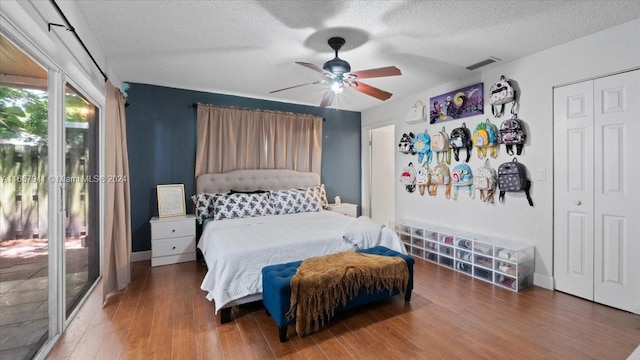 bedroom featuring access to exterior, a textured ceiling, ceiling fan, hardwood / wood-style flooring, and a closet