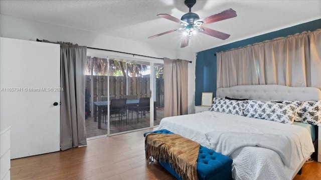 bedroom featuring hardwood / wood-style flooring, ceiling fan, access to exterior, and a textured ceiling