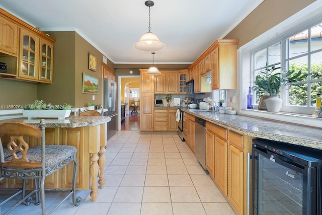 kitchen featuring appliances with stainless steel finishes, beverage cooler, pendant lighting, a breakfast bar, and ornamental molding