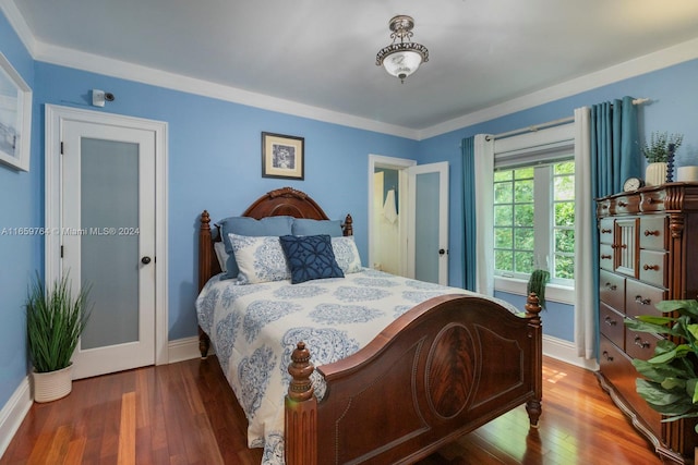 bedroom with crown molding and dark wood-type flooring