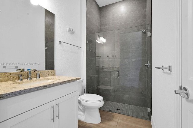 bathroom featuring tile patterned floors, vanity, toilet, and an enclosed shower