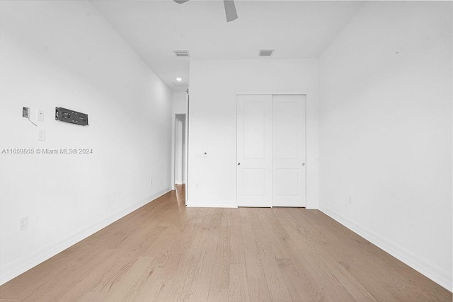 unfurnished bedroom with ceiling fan, a closet, and light wood-type flooring