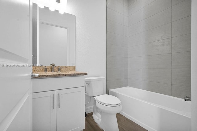 full bathroom featuring hardwood / wood-style flooring, vanity, toilet, and tiled shower / bath