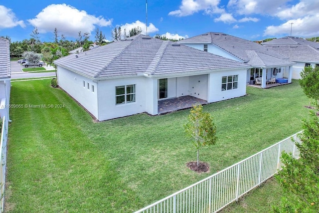 back of house with a lawn and a patio area