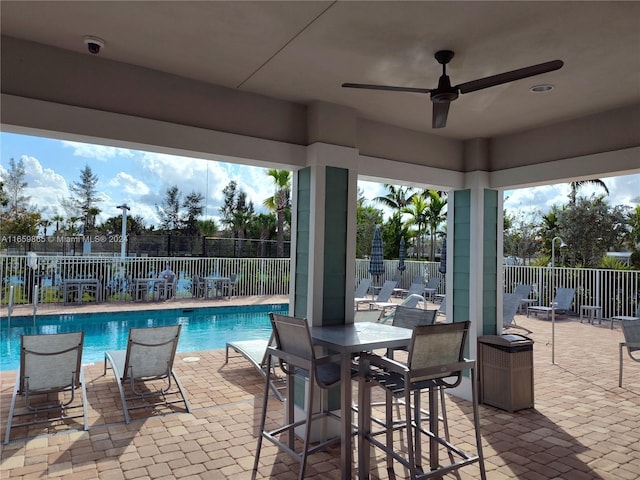 view of swimming pool with ceiling fan and a patio