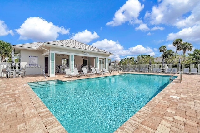 view of swimming pool with ceiling fan and a patio area