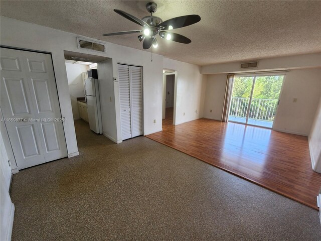 8240 SW 210th St Unit 302, Cutler Bay, FL 33189 - unfurnished bedroom featuring freestanding refrigerator, access to exterior, a textured ceiling, baseboards, and wood finished floors