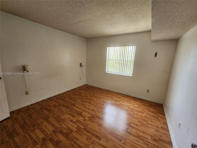 8240 SW 210th St Unit 302, Cutler Bay, FL 33189 - spare room with wood finished floors, a textured ceiling, and baseboards