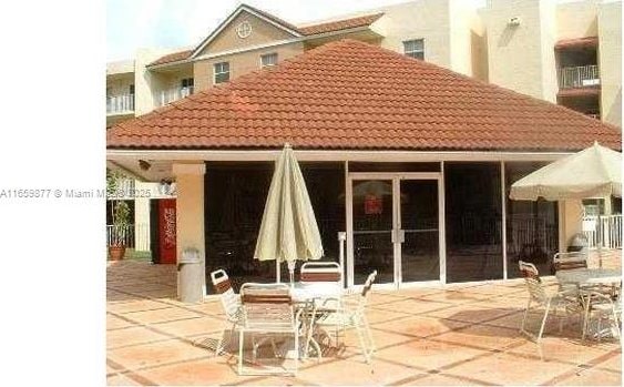 8240 SW 210th St Unit 302, Cutler Bay, FL 33189 - back of property featuring a tiled roof, a patio, and outdoor dining space