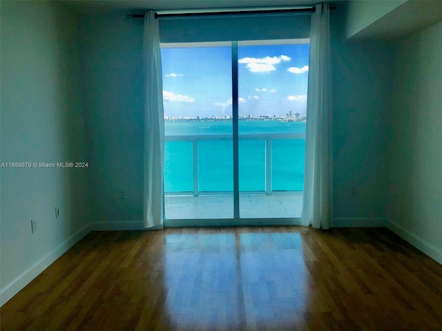 empty room with wood-type flooring and a water view