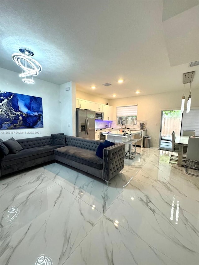 living room featuring an inviting chandelier and a textured ceiling