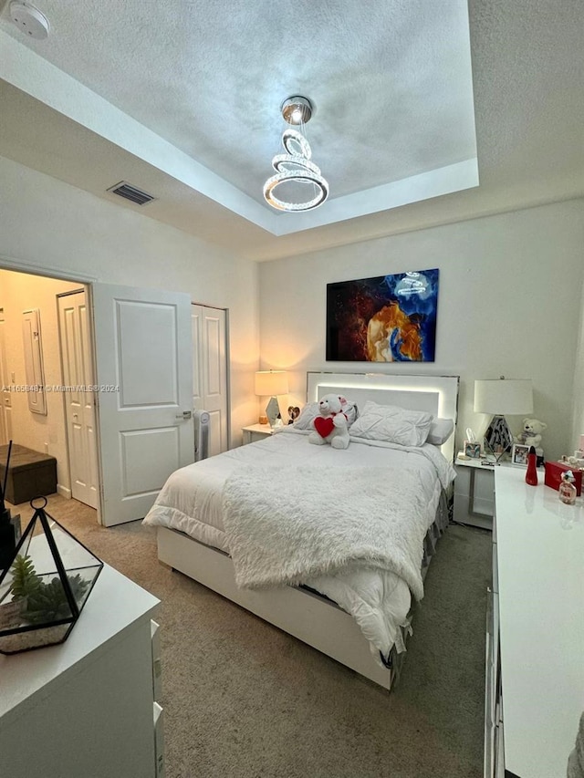 bedroom featuring a textured ceiling and carpet flooring