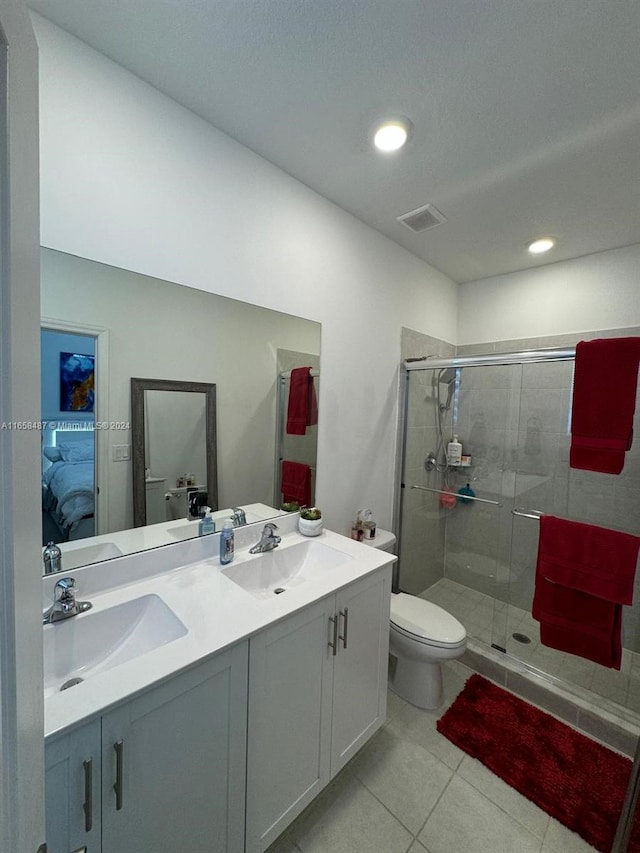 bathroom featuring vanity, toilet, tile patterned flooring, and a shower with door