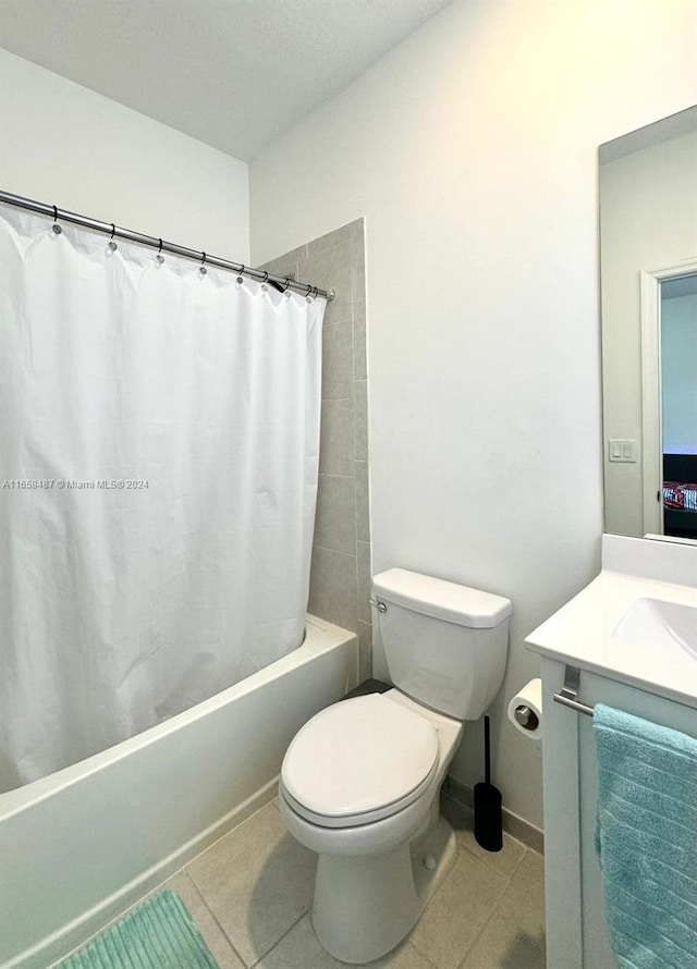 full bathroom with tile patterned floors, shower / bathtub combination with curtain, toilet, and vanity