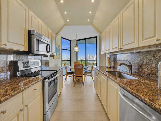 kitchen with dark stone countertops, appliances with stainless steel finishes, decorative backsplash, and pendant lighting