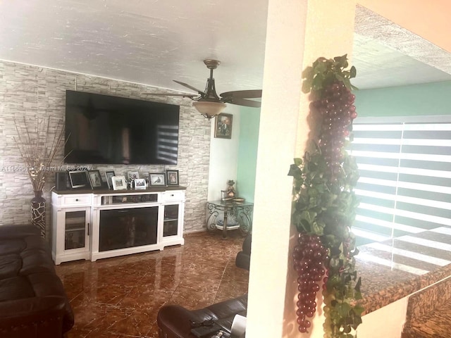 living room featuring ceiling fan and a textured ceiling